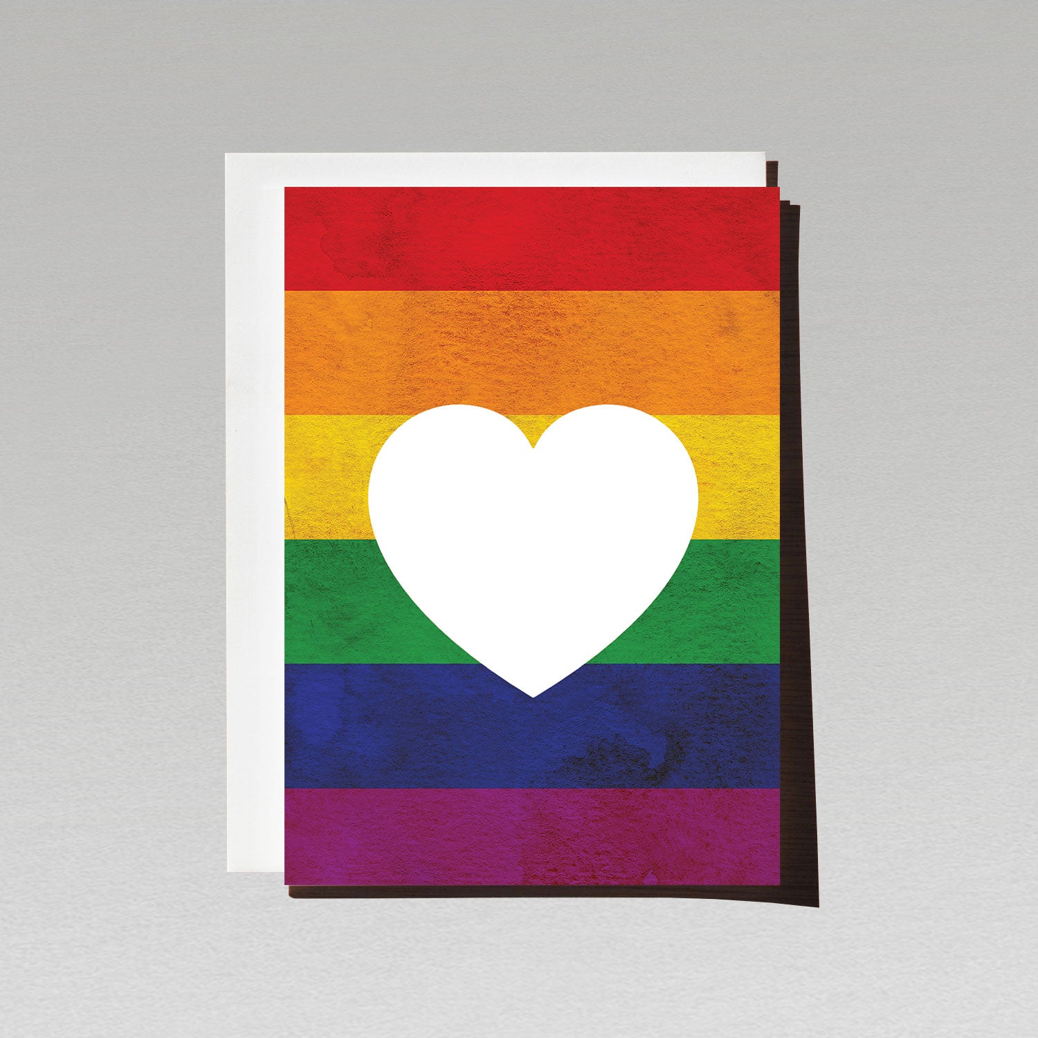 Greeting card with large white love heart sitting on LGBTQI rainbow flag background